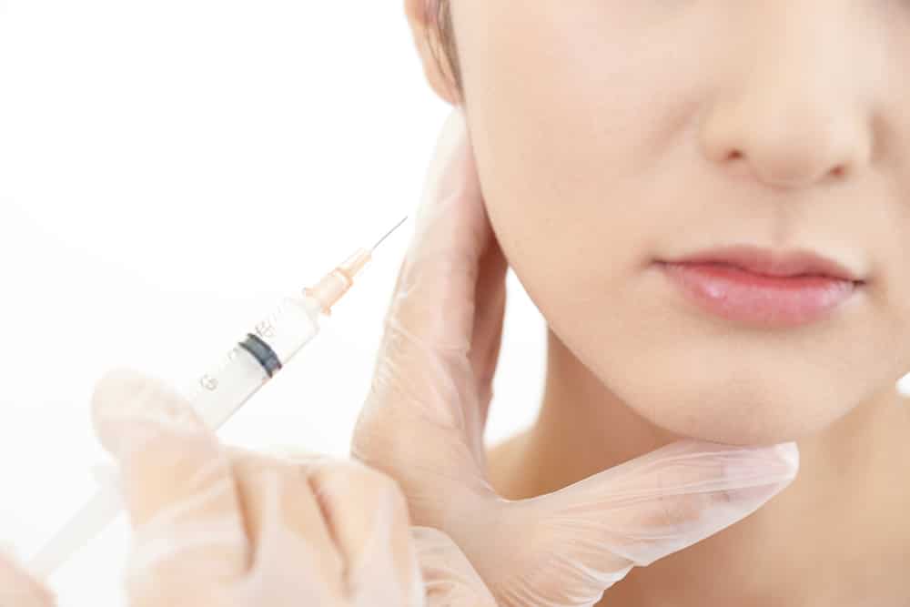 Dentist applying dental fillers to a patient